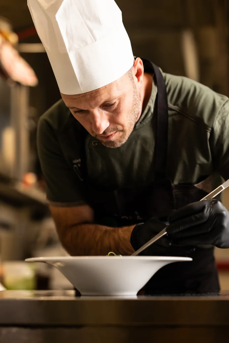 Lo chef di Olì Olà rifinisce un piatto in cucina