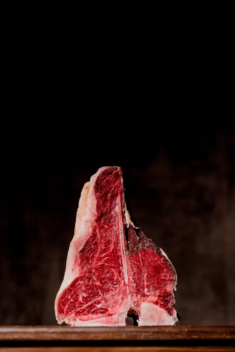 Taglio di carne frollata fotografato su fondo nero