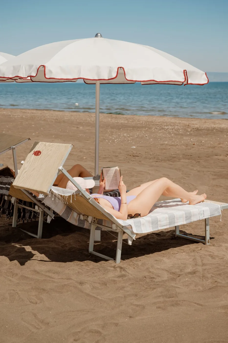 Lettura in relax su lettino sotto l’ombrellone in riva al mare