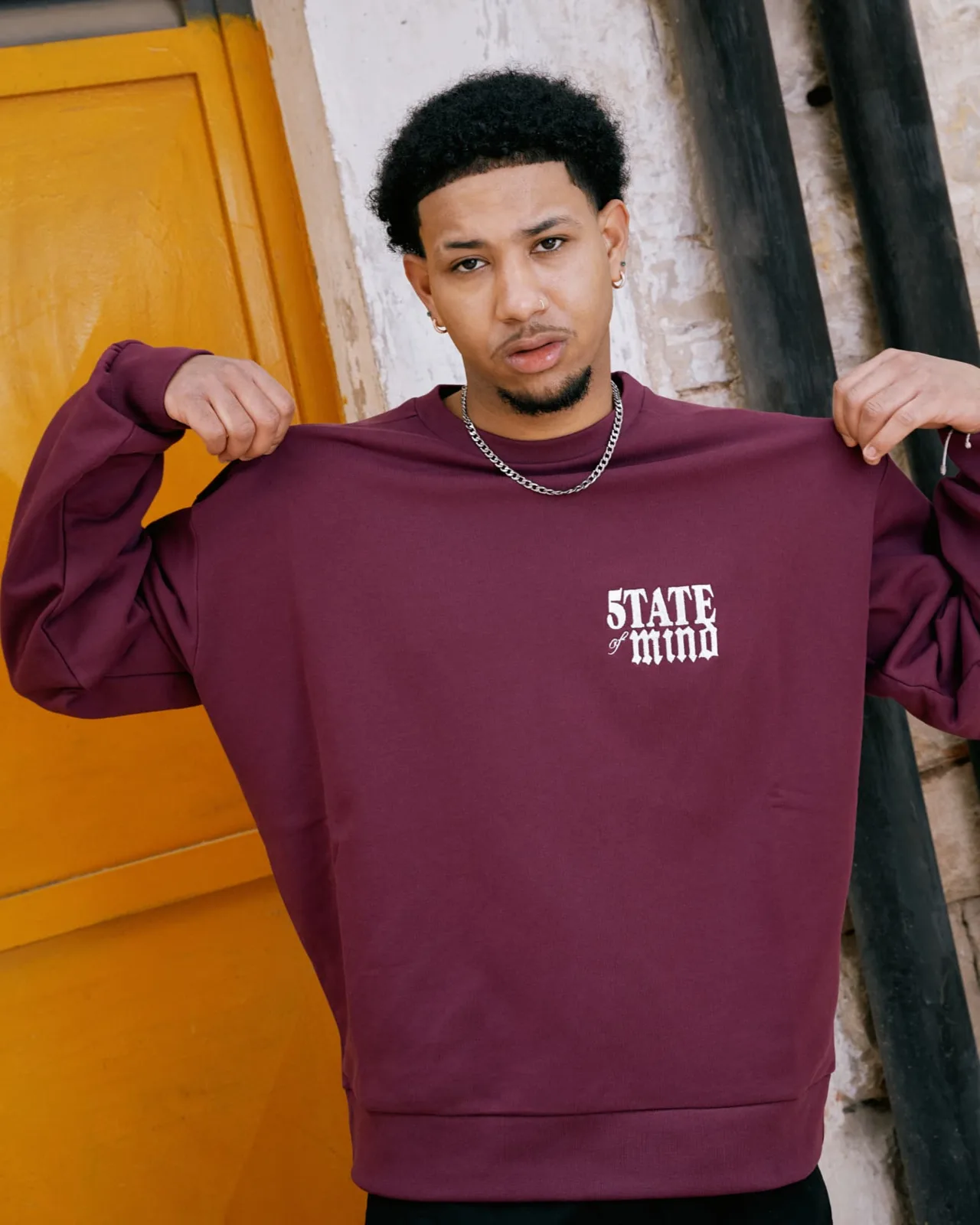 Modello che mostra il fronte della felpa bordeaux con logo ricamato