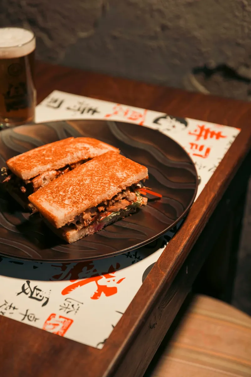 Toast farcito con calice di birra artigianale su tavolo in legno