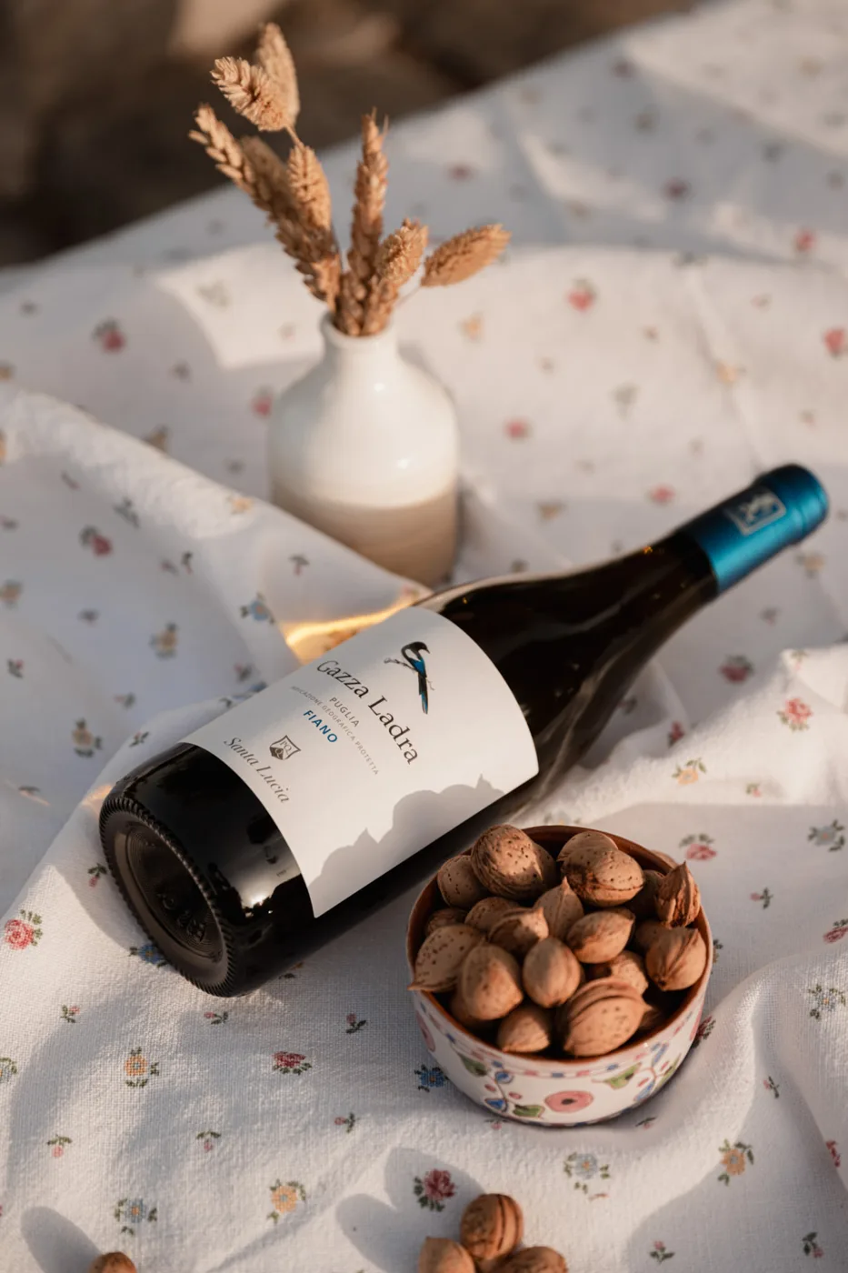 Bottiglia Gazza Ladra Fiano con ciotola di mandorle