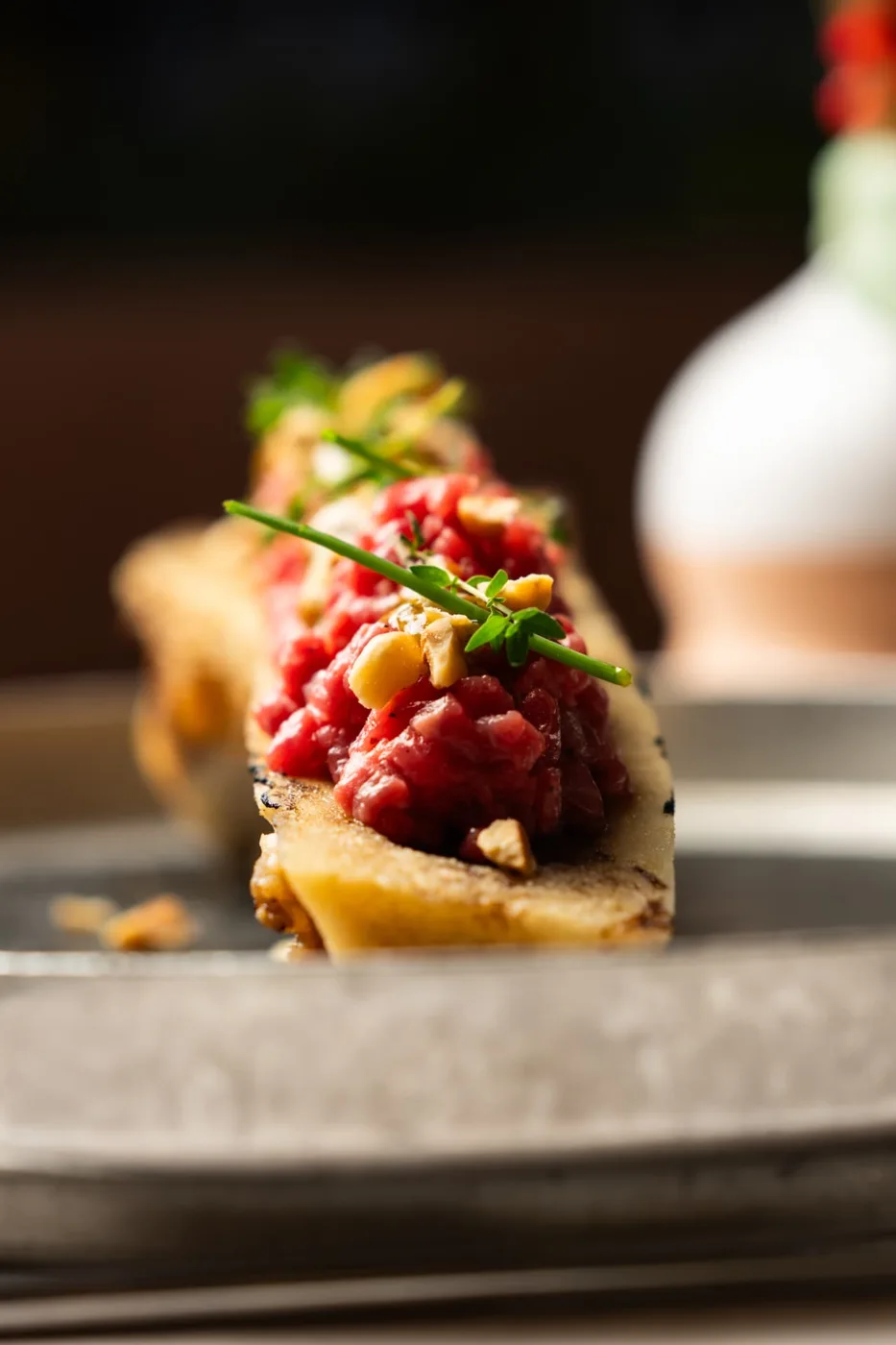 Dettaglio ravvicinato della tartare con nocciole ed erbe