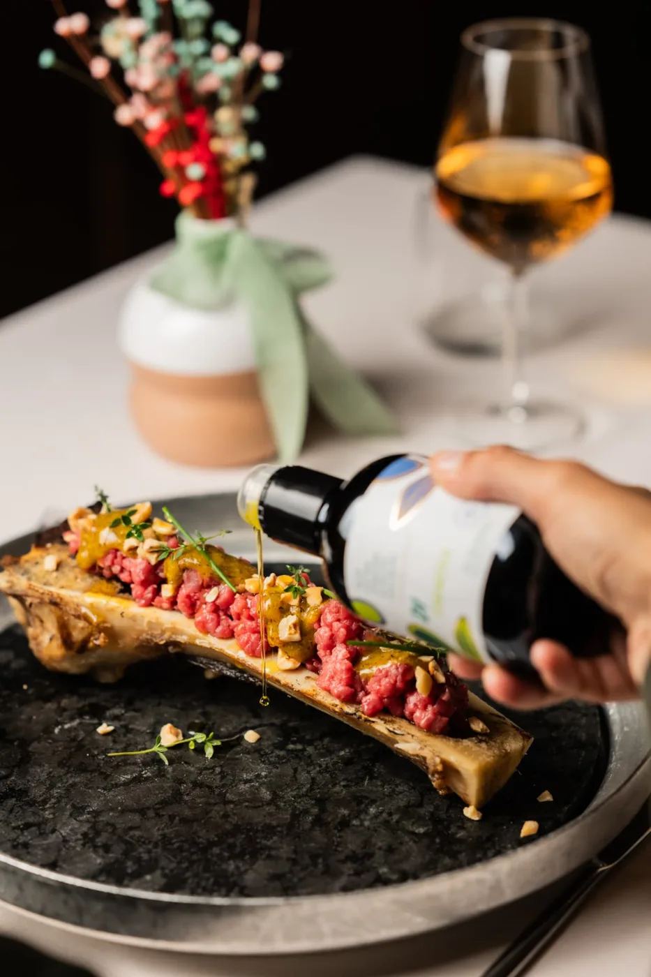 Olio in caduta su tartare di manzo servita nell’osso